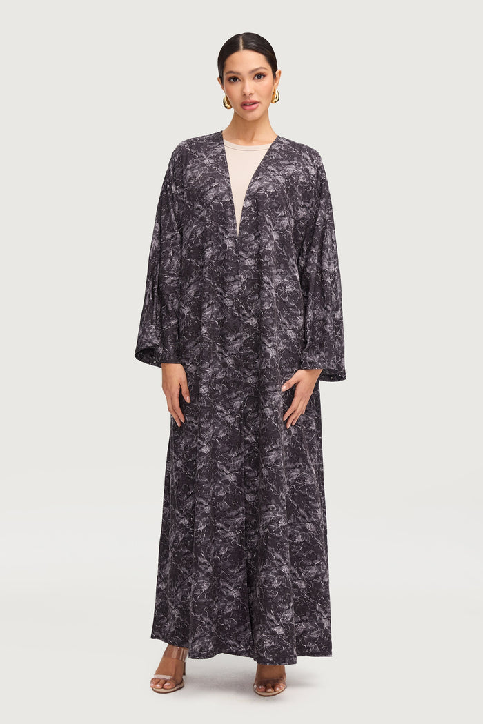 A woman wearing a printed black abaya